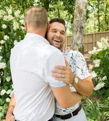 man in white shirt hugging woman in white shirt